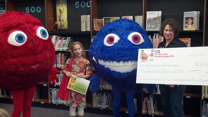 Greer, flanked by Price Chopper's mascots, finds out she won the award.
