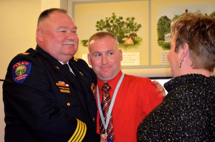 Retiring Roeland Park Police Chief Rex Taylor is congratulated by his son, Adam, and wife, Mary, after his retirement ceremony.