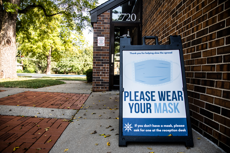 a sign advises people to wear a mask because of a face mask ordinance in the city