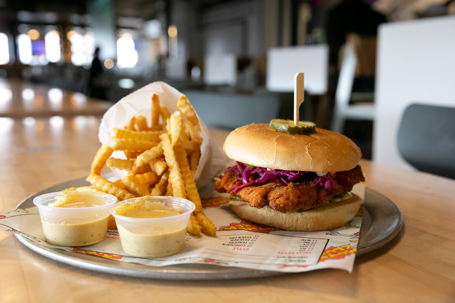Mother Clucker! hot chicken served on a sandwich with crinkle-cut fries, a mainstay on their menu at the original Mother Clucker! location inside Parlor food hall in Kansas City, Missouri.