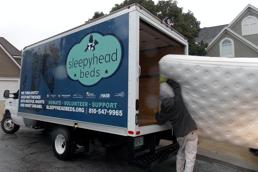 Sleepyhead Beds employee loads mattress