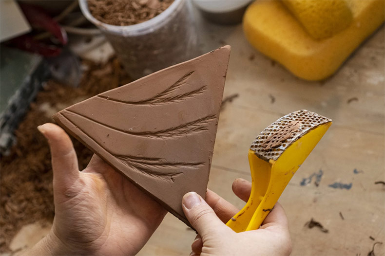 Artist Kirsten Taylor forms a clay tile that will be part of her Shawnee Mission Park art installation.