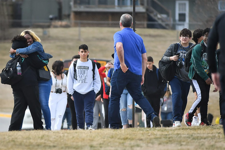 Students evacuate the building following a shooting at Olathe East High School.