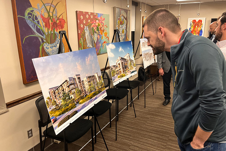 Roeland Park resident Dru Walstrom views conceptual renderings of EPC's The Rocks plan on Wednesday night. Photo credit Bek Shackelford-Nwanganga.