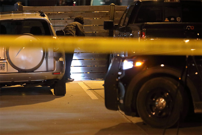 Crime lab investigator collects evidence at scene of downtown Shawnee shooting.