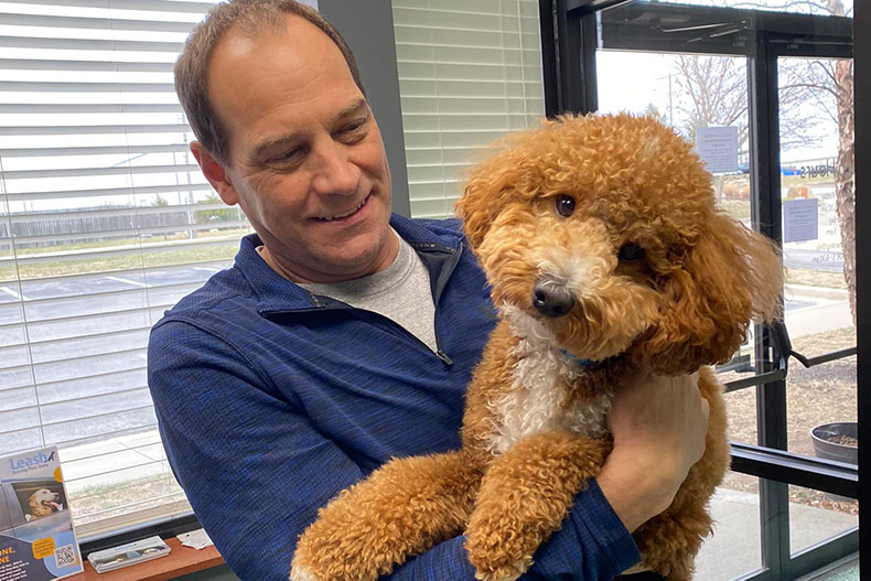 A human and a fluffy dog at Ruff Ranch KC.