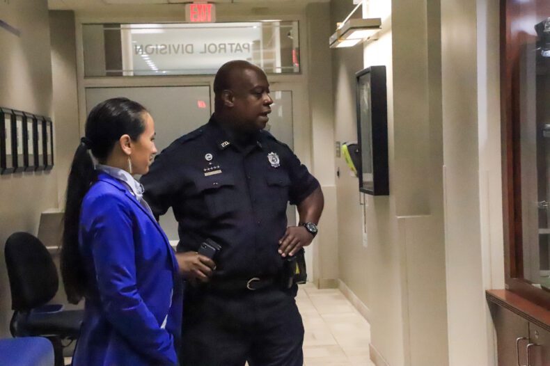 Rep. Sharice Davids and Officer John Lacy touring the Overland Park Justice Center and police department on Monday, July 31. The two are viewing the memorial to Officer Mike Mosher, who was killed in the line of duty in 2020.
