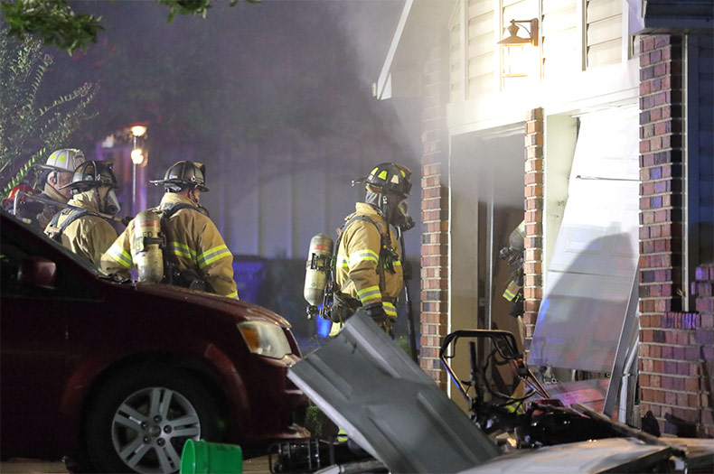 Shawnee firefighters enter the garage where a fire and disturbance took place.