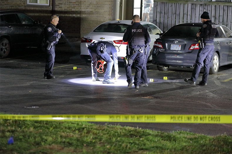 Shawnee Police officers mark evidence in the parking lot of the Fox Fun Luxury Apartments in Shawnee Monday night.