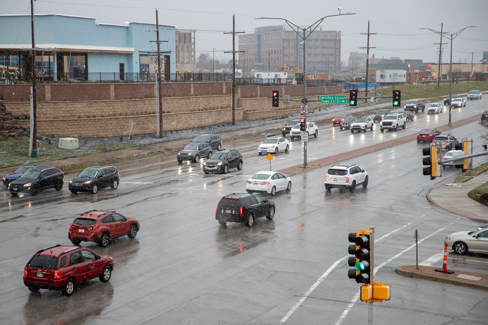 Cars navigate the intersection at Nall and 117th in Overland Park Monday afternoon as flurries picked up