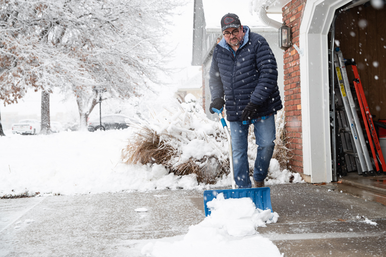 Matthew Brinson shovels his driveway for the second time on the morning of Tuesday, Jan. 9, in his Overland Park neighborhood. He first shoveled around 5 A.M. before shoveling again around 8 A.M. After clearing his own driveway he is headed to shovel his mother’s.