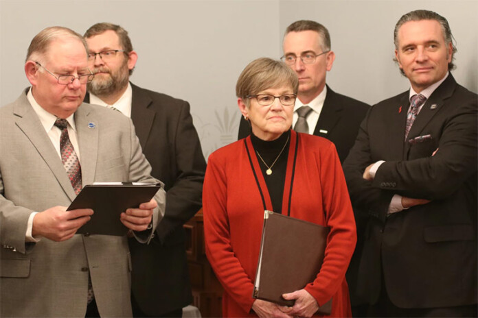 Democratic Gov. Laura Kelly, center, is likely to butt heads with Republican leaders in the Kansas Legislature — House Speaker Dan Hawkins, left, and Senate President Ty Masterson, right — during the 2024 session. Kelly has called for expanding Medicaid, while Hawkins and Masterson said they are focused on tax cuts and school choice options.