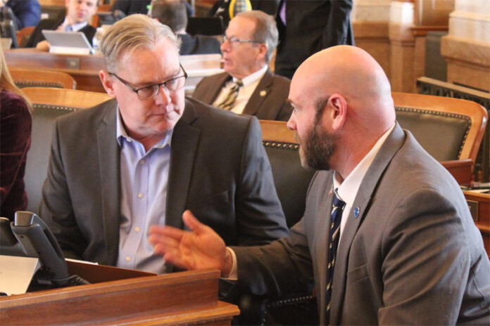 Republican Reps. Sean Tarwater (left) and Stephen Owens talk Thursday on the House floor before discussion on the tax reform bill. The bill passed 81-37 and will now be sent to Democratic Gov. Laura Kelly.