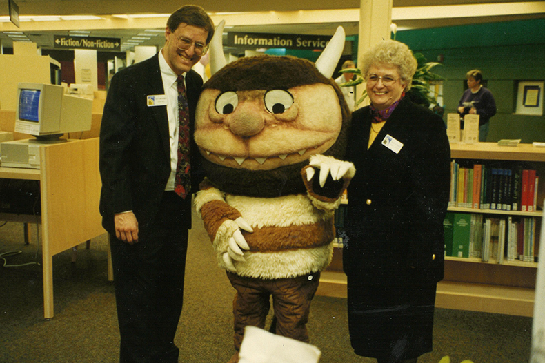Johnson County Library representatives believe the photo above is also from the re-opening ceremony of Antioch Library. From left to right, Scott Wasserman of the Library Board, the Wild Thing, and then-County Librarian Mona Carmack. Photo courtesy Johnson County Library. 