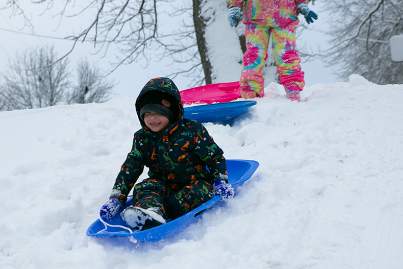 A boy sleds down a short hill in eastern Shawnee on Jan. 9, 2024.