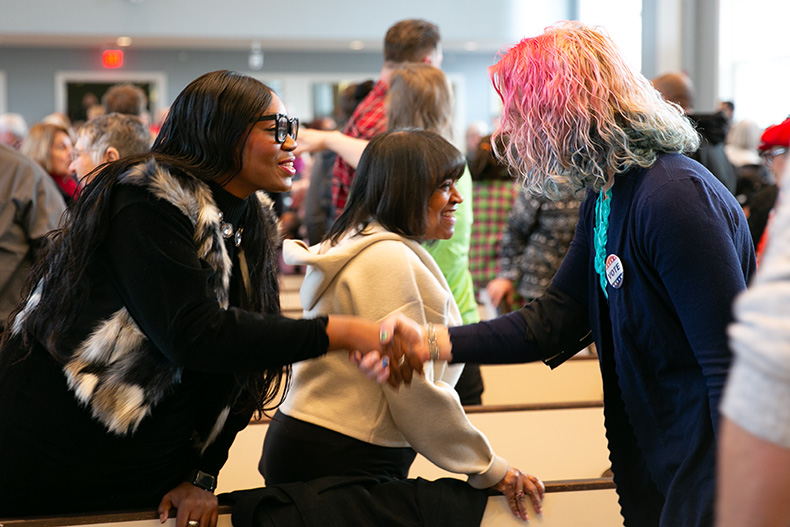 Two crowd members greet each other at the 2024 Prairie Village MLK celebration.