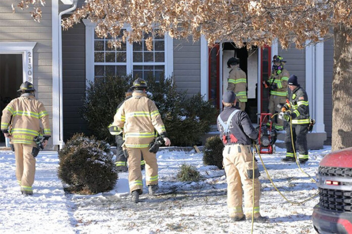Shawnee firefighters in the front yard of a home that caught fire Tuesday, after the fire had been brought under control. Photo credit Mike Frizzell.