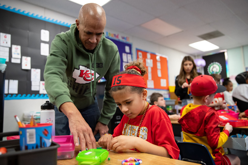 First grader Adria Wickliff makes a friendship bracelet with her father Shane on Thursday Morning at Heatherstone Elementary. Photo credit Kylie Graham. 