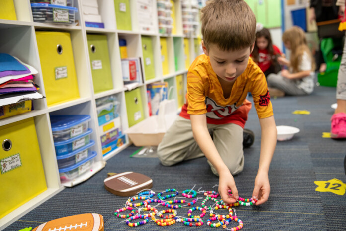 First grader Joshua Weyant counts the total number of bracelets Mrs. Smith’s first-grade class made to send to John Sutter Elementary in Santa Clara, California. Photo credit Kylie Graham.