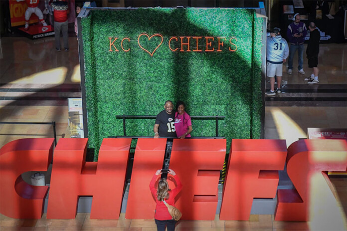 Visitors to Union Station on Feb. 2 pose with one of the displays in the Grand Ballroom celebrating the Chiefs AFC championship and their upcoming Super Bowl matchup. Photo credit Carlos Moreno/KCUR 89.3.