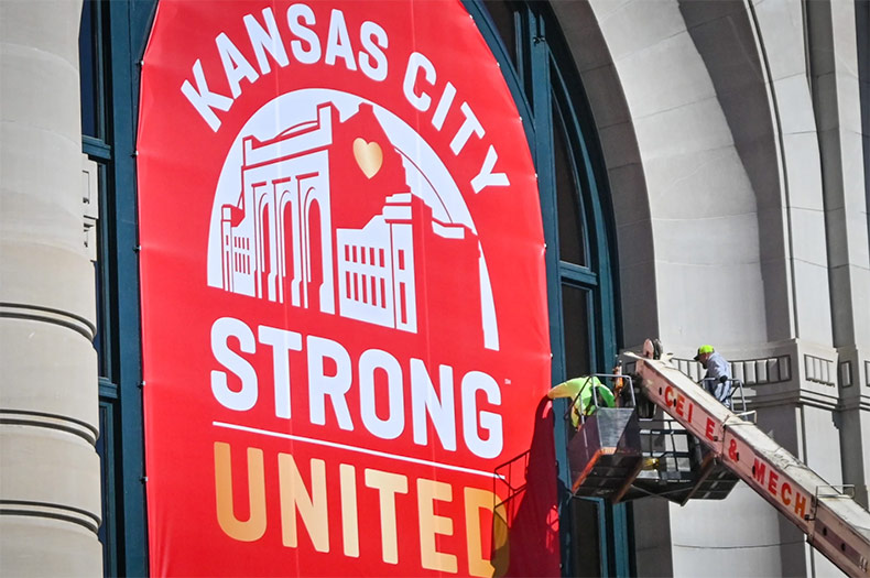 A crew from CEI Electrical and Mechanical hangs a banner on Union Station Monday morning near where one person died and 22 people were injured in a shooting on Jan. 14 after the Chiefs Super Bowl celebration rally. Photo credit Carlos Moreno/KCUR 89.3.