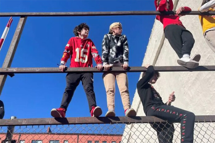 Children find a higher vantage from which to watch Wednesday's Super Bowl parade through downtown Kansas City. Photo credit Celisa Calacal/KCUR 89.3.