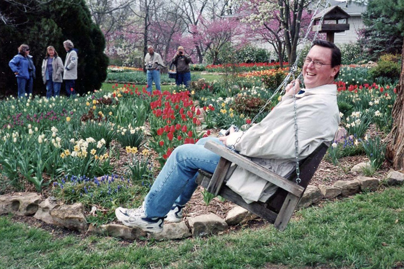 Dennis Patton swings near a garden