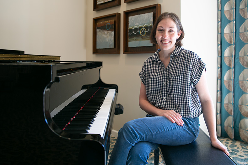Claridge Court UMKC student at the piano in the community's rotunda. 