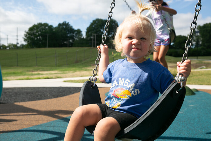 A young girl named Iris plays on a brand new swing set at the reimagined Water Works Park in Mission, following a ribbon cutting ceremony for the newly unveiled park. Photo credit Juliana Garcia.