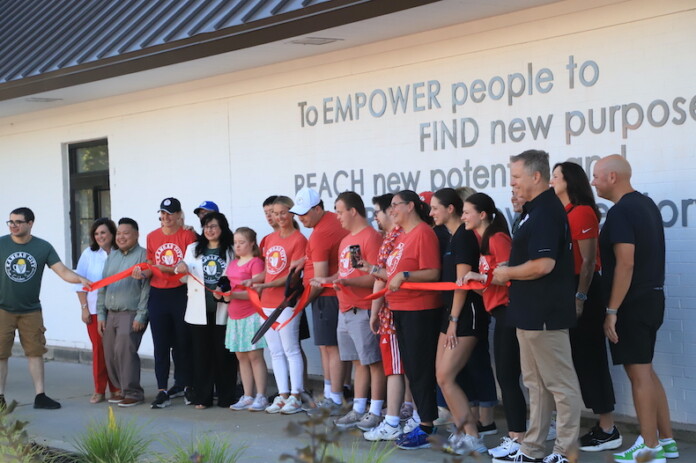 Trey Lockwood (center) cuts the ribbon on the new Golden Scoop location in Overland Park.
