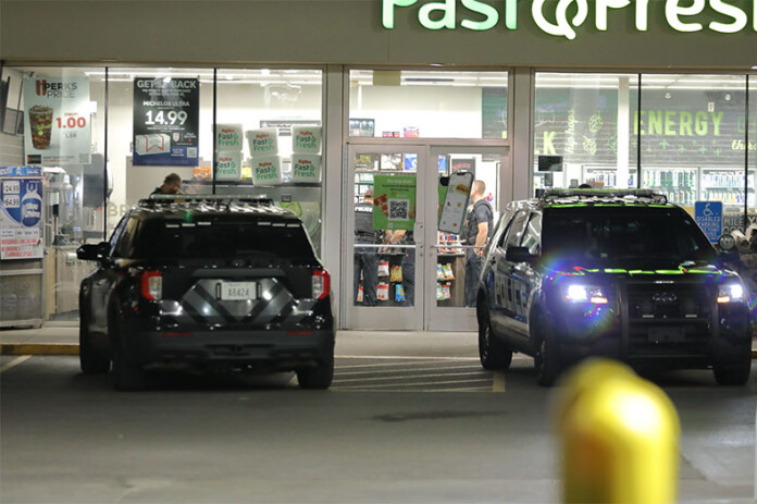 Police officer inside a Hy-Vee convenience store in Mission investigating a reported armed robbery Monday night. Photo credit Mike Frizzell.