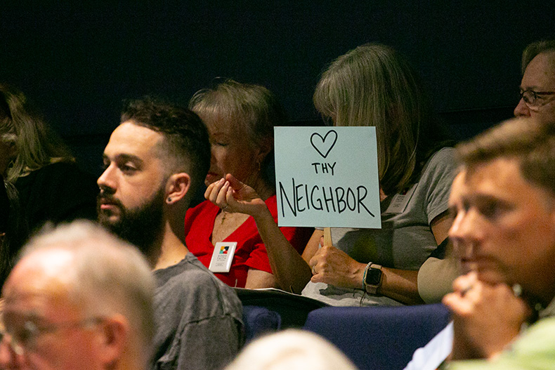 Love thy neighbor sign at the Lenexa City Council meeting. Photo credit Leah Wankum.