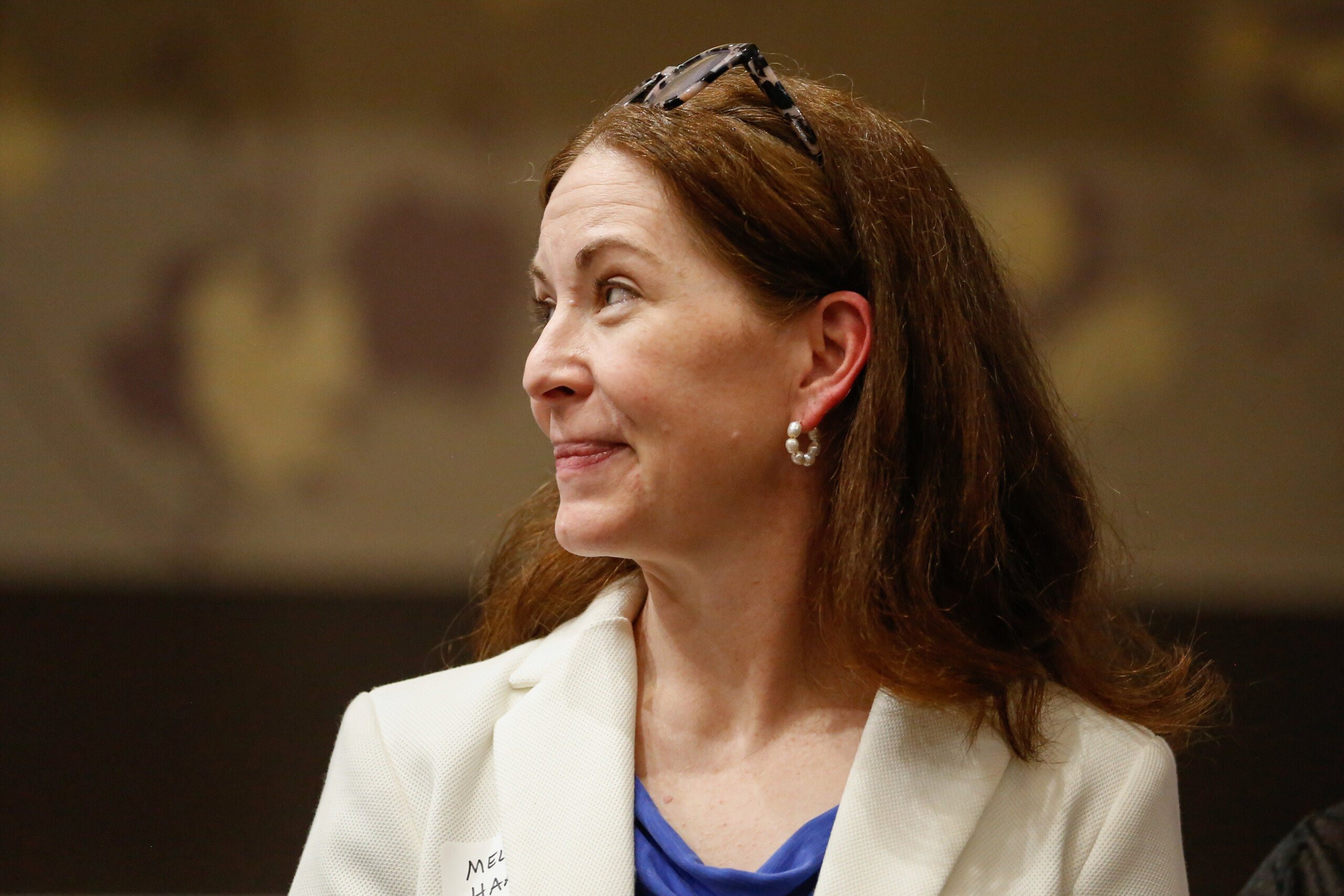 Kansas State Board of Education member Melanie Haas listens to Gov. Laura Kelly give a speech at the Johnson County Democratic Party's watch party.
