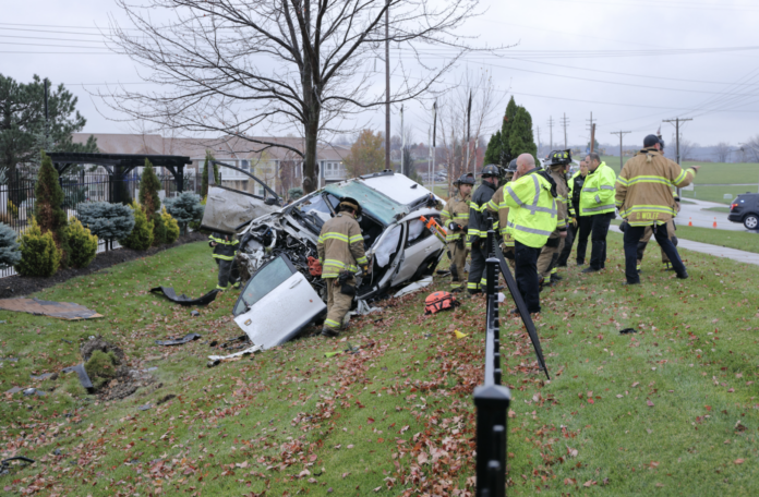 Emergency crews around a car that ran off the road near 67th Street and Lackman Road on Wednesday, hitting a building at an apartment complex. Photo credit Mike Frizzell.