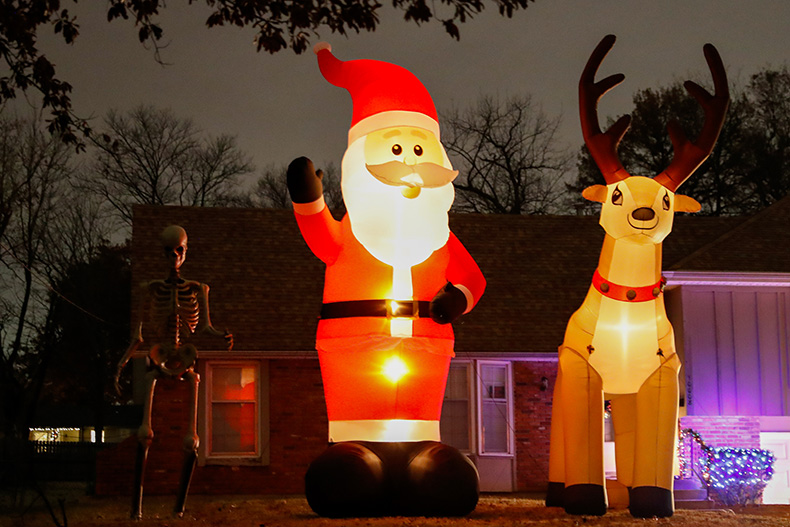 An inflatable Santa and Rudolph stand next to a large skeleton outside of a home at Mastin Street and West 61st in Merriam.