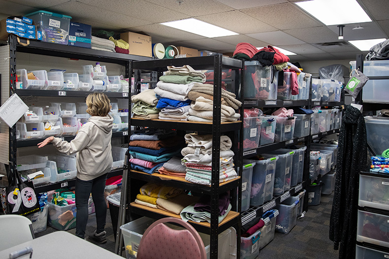 Volunteer Kathleen Osbern looks through products in the supply room at Project 1020.
