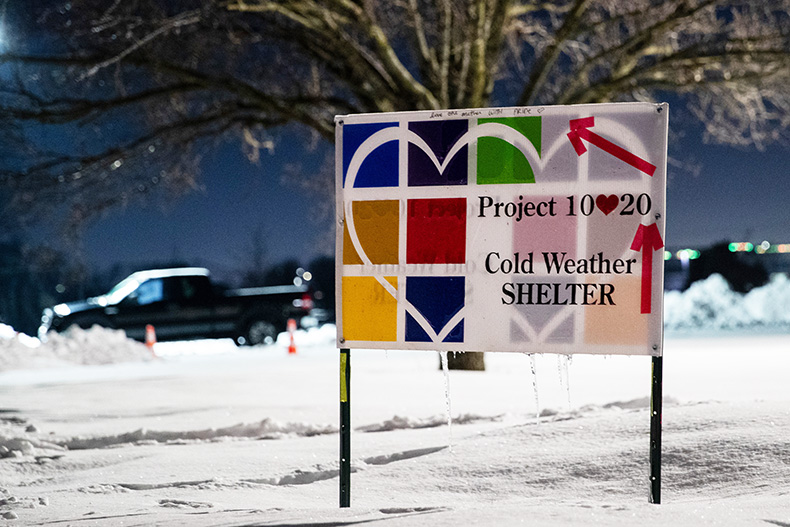 A sign directs people to the Project 1020 cold weather shelter entrance at Shawnee Mission Unitarian Universalist Church.