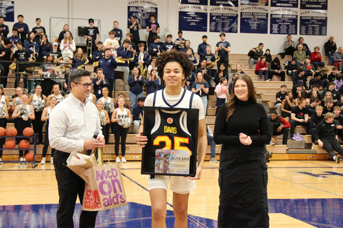 Blue Valley North senior Jaliya Davis (center) accepts a commemorative McDonald's All-American jersey after a game on Friday, Feb. 21. Photo credit to Trozzolo Communications Group.