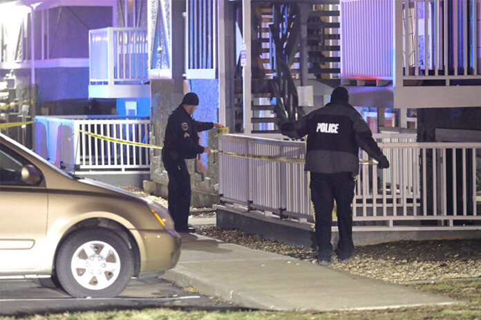 two Olathe officers putting up crime scene tape after the search ended.