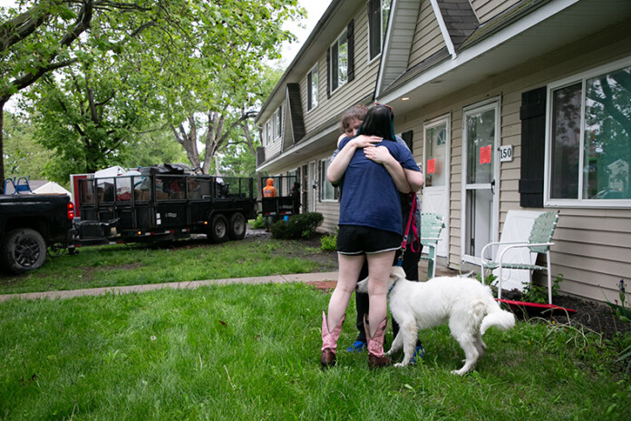 Two neighbors Cassie Biesik (left) and Leana Burkey embrace as they cross paths working to pack up their belongings. Burkey said she’s worried about where the children at Aspen Place will go, especially her students at a nearby elementary school where she works as a paraprofessional.
