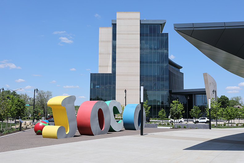 Decorative letters spelling "JOCO" adorn the grounds of the Johnson County Square in Olathe. The Johnson County Courthouse is in the background.