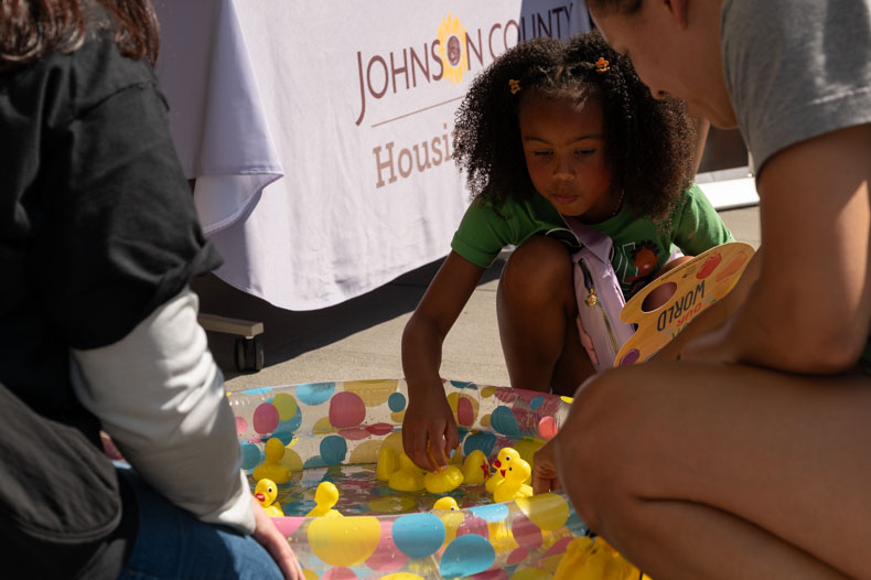 Kyndrik, age 7, fishes for the winning duck at the Johnson County Housing Services Department’s table. Various departments of the Johnson County government tabled at the celebration to promote their services and diversity, equity and inclusion initiatives.