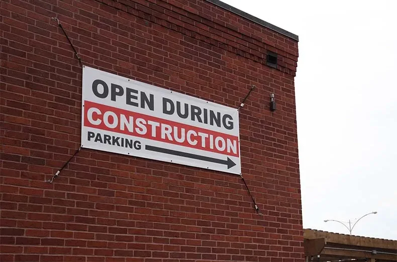 A sign on the north side of Brew Lab's building lets customers know it's still open during construction.