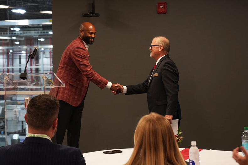 Justin Bridgeman (left),CEO of Heartland Coca-Cola, shakes hands with Olathe Mayor John Bacon during the grand opening celebration.