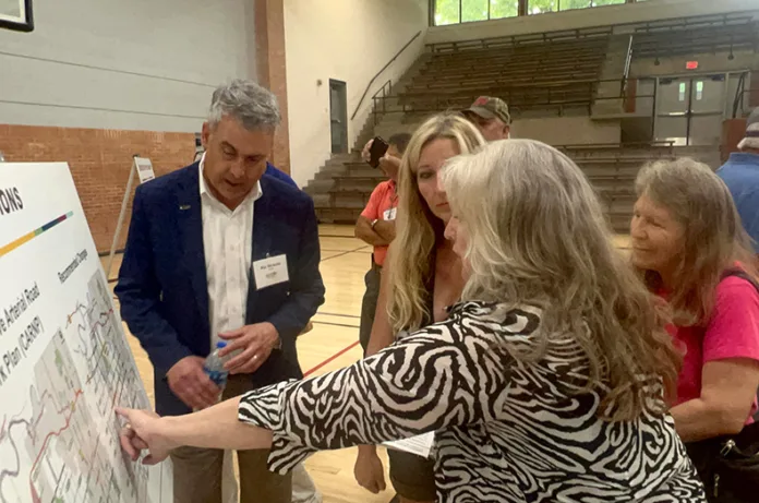 Edgerton Road resident Lisa Huppe illustrates on a map to HNTB Transportation Director Kip Strauss how the county’s proposed plan to widen and increase speed limits on Edgerton Road would ruin her property.