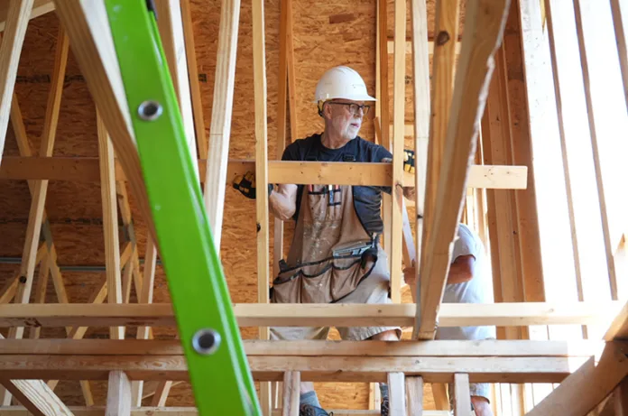 A regular volunteer with Habitat for Humanity, Ralph Graham, helps place supports for the ceiling of one of 14 single-family homes as part of Habitat for Humanity and Pathway Community Christian Church’s affordable housing project in Olathe.