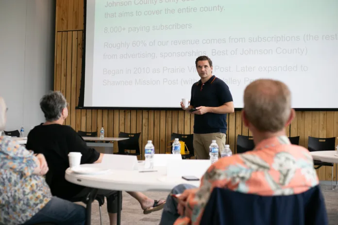 A picture of Johnson County Post editor Kyle Palmer talking to a group of Olathe residents.