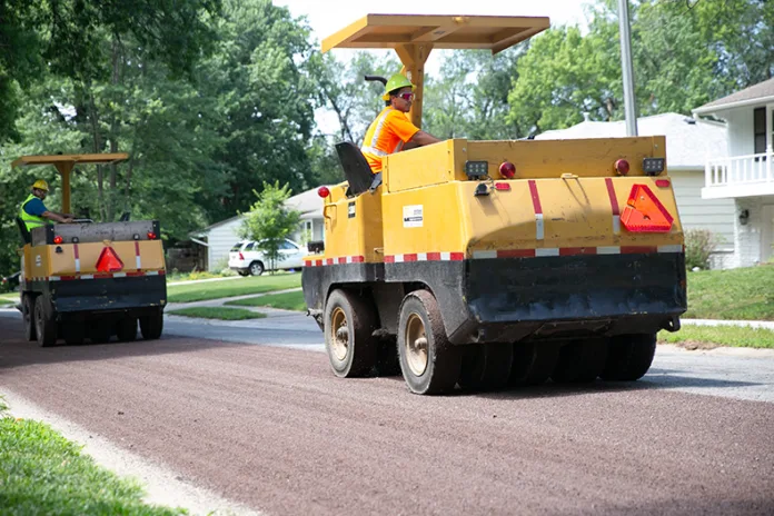 Crews lay chip seal on a street in the Westbrooke neighborhood of Overland Park in June 2025.