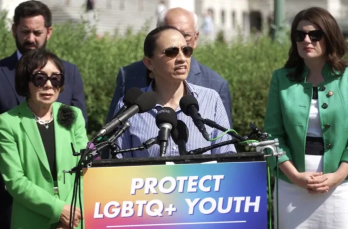 U.S. Rep. Sharice Davids (center) spoke at a press conference Thursday outside the U.S. Capitol advocating for the protection of a hotline for LGBTQ youth.