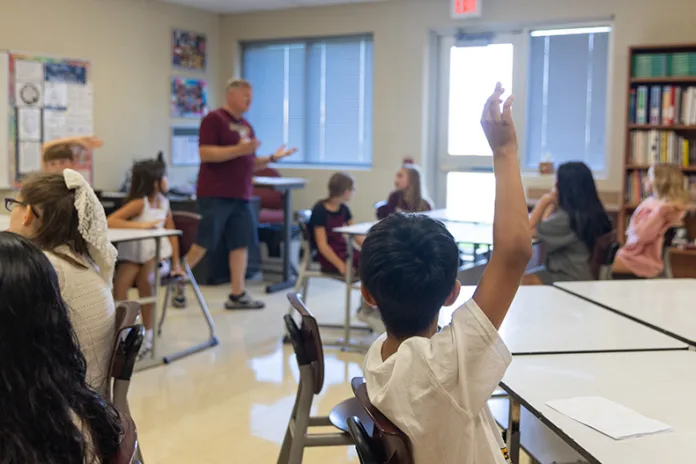 A fifth-grade student in Chris Frye’s art class raises his hand to share with the class on the first day of school at Pioneer Ridge Middle School on Aug. 13.